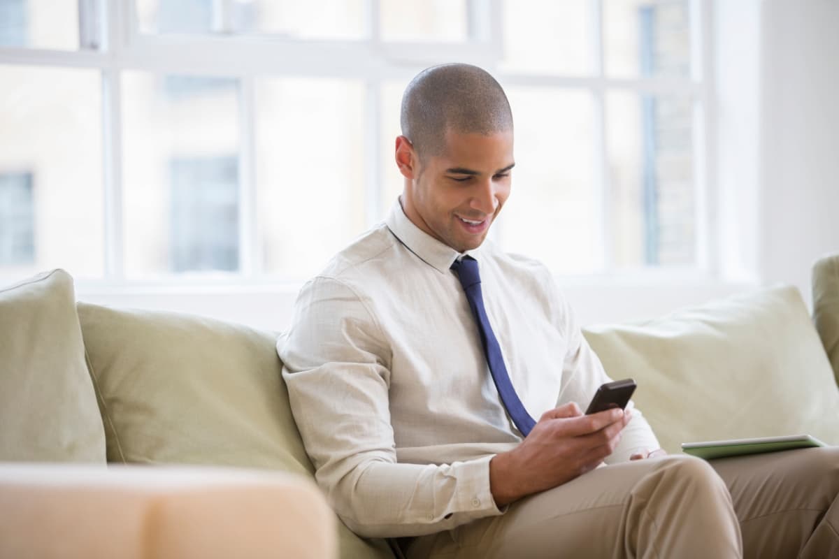 Homem de negócios usando smartphone, exemplificando mobilidade corporativa.