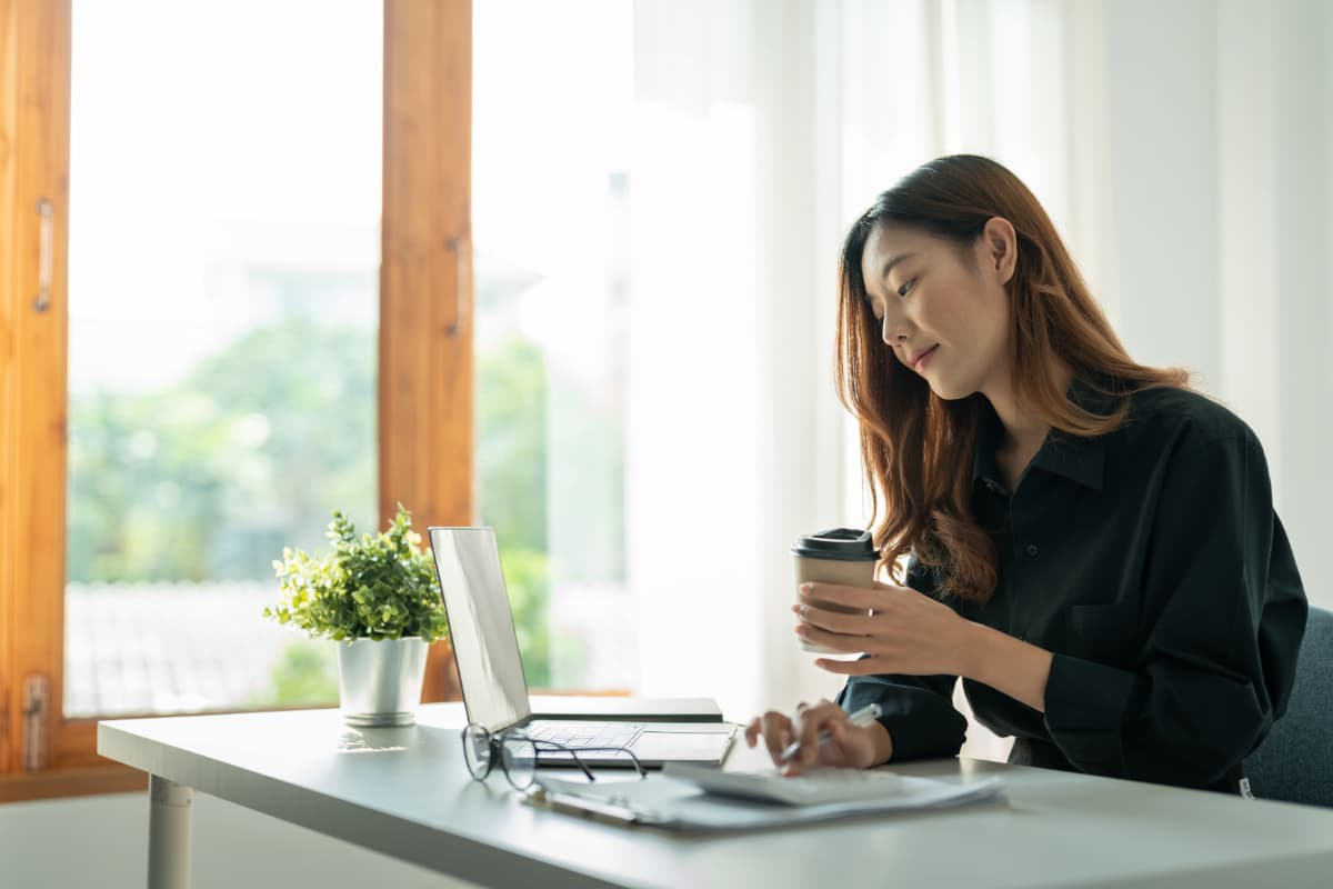 Mulher em escritório analisa finanças, representando gastos de pequenas empresas.