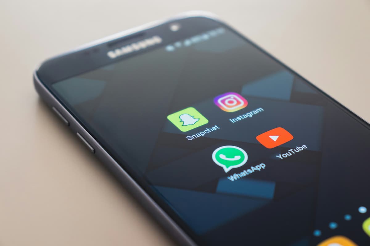 Smartphone Samsung exibindo ícones de apps, incluindo WhatsApp corporativo.