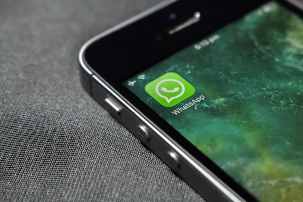 Smartphone exibindo ícone do WhatsApp corporativo na tela.