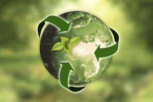 Planeta Terra verde, enlaçado pelo símbolo da reciclagem também verde.