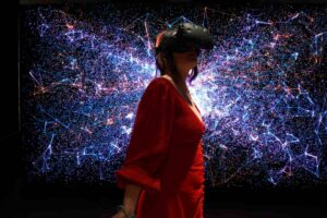 Fotografia de uma mulher que utiliza óculos de realidade virtual para acessar o metaverso.