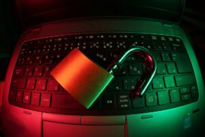 Cadeado sobre teclado de laptop iluminado em vermelho, simbolizando a segurança da licença de software.