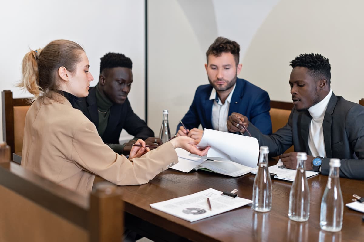 Equipe corporativa discutindo documentos e estratégias em uma reunião de negócios.