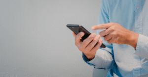 Profissional utilizando smartphone corporativo, representando a importância da gestão de dispositivos móveis nas empresas e de implementar mdm